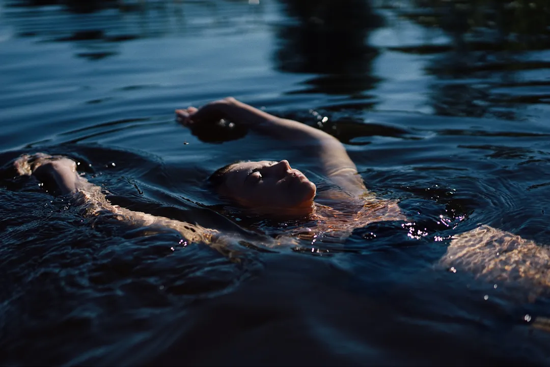 A woman floating on her back in tranquil water