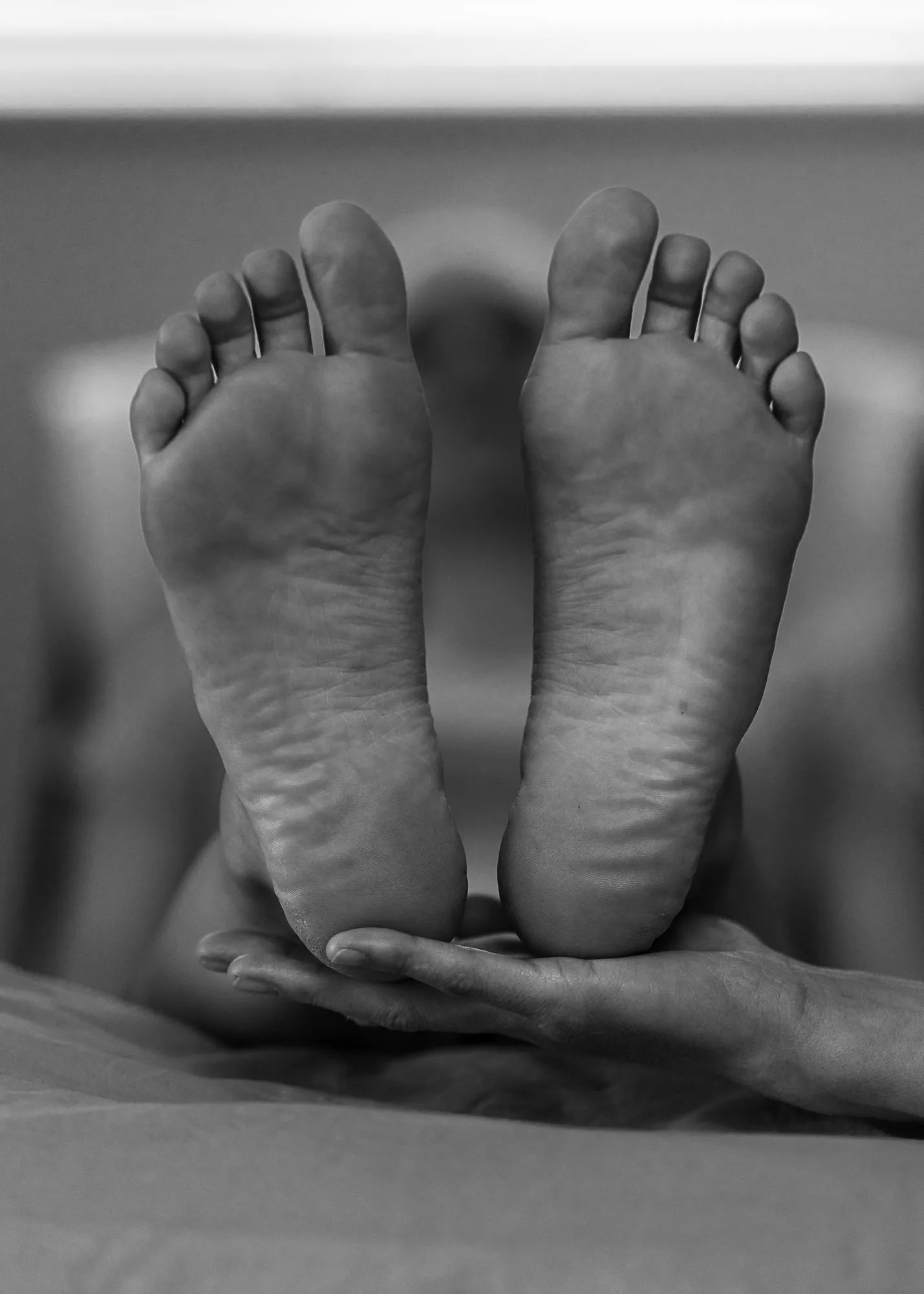 The soles of two feet being treated with reflexology